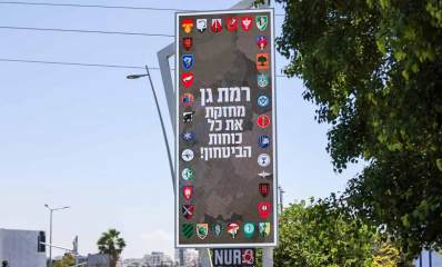 שלט רחוב לחיזוק כוחות הביטחון ועליו סמלים של יחידות צה"ל וכוחות הביטחון. הכיתוב על השלט: רמת גן מחזקת את כל כוחות הביטחון! כמוב עליו רמת גן מחזקת את כל כוחות הביטחון