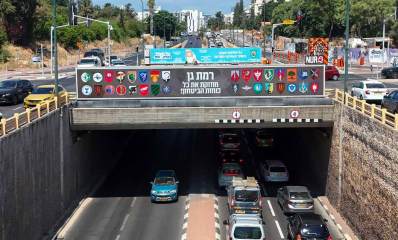 שלט מעל מנהרה לרכב, לחיזוק כוחות הביטחון, ועליו סמלים של יחידות צה"ל וכוחות הביטחון. הכיתוב בשלט: רמת גן מחזקת את כוחות הביטחון!