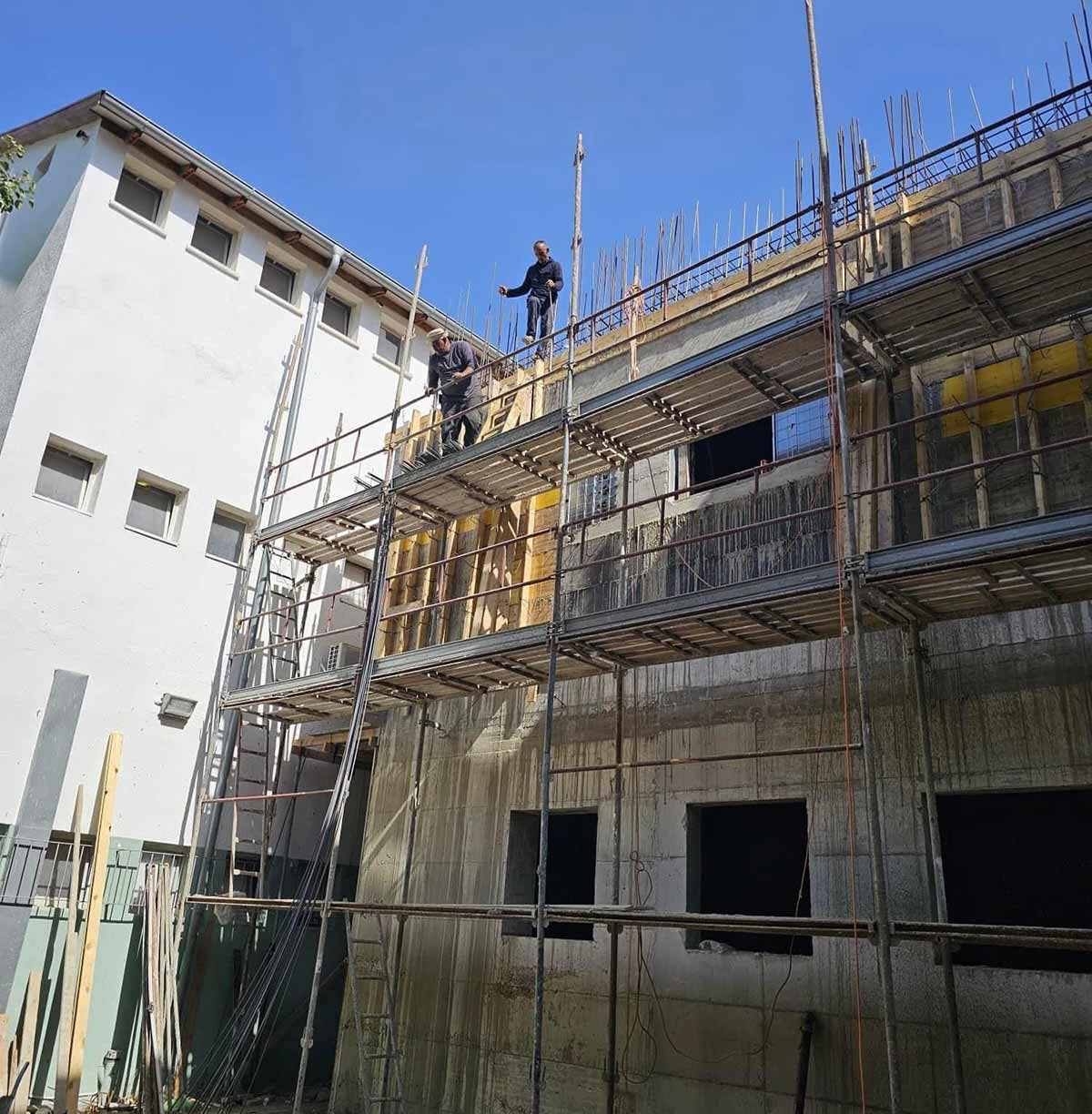 מיגון בתי ספר בגבעתיים. בחזית בית הספר יוצקים קיר עם ברזלים.