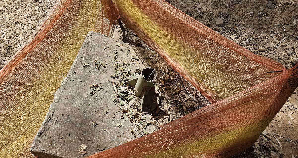 משטח בטון בגן הקופים עם בסיס של עמוד מתכת בתוכו. מסביבו גדר של רשת מבד.