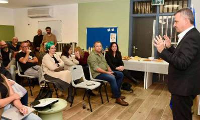 נחנך מרכז תעסוקתי לבוגרים. נשים וגברים יושבים בשורות באולם לא גדול ומולם עומד ומדבר ראש העיר בחליפה שחורה. בצד על שולחנות מונח כיבוד.
