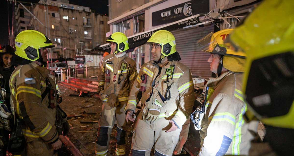 לוחמי אש לבושים בחליפות ההצלחה וקסדות בזירת הנפילות ברמת גן