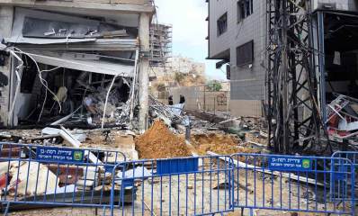 חנות חליפות שנפגעה ברחוב בן גוריון. חזית החנות נעלמה השלט והגגון הרוסים. בפנים החנות חורבות. השברים על המדרכה.