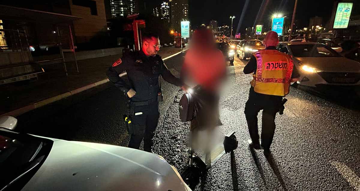 אכיפת תנועה במרחב דן. שני שוטרים ליד אישה, ורכב לבן לידם.