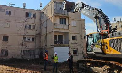 הריסות במתחם "המאבק וההסתדרות" בגבעתיים. שלושה עובדים ליד כלי כבד מוכן להריסה של בית בן 4 קומות.