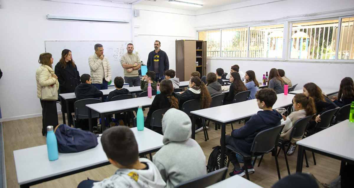 תלמידי בית הספר ברמת אפעל שבו ללימודים בשכונה. התלמידים יושבים בכיתת לימוד ולפני הלוח עומדים חמישה מבוגרים.