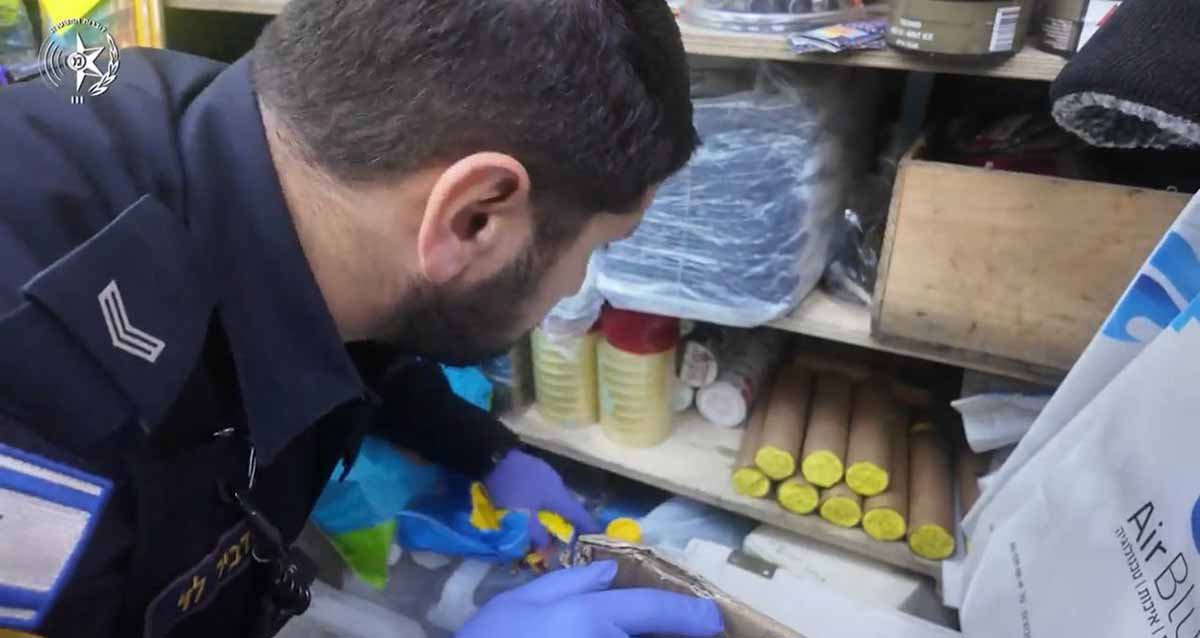 היערכות מוגברת לפורים ברמת גן. שוטר עורך בדיקה בחנות.