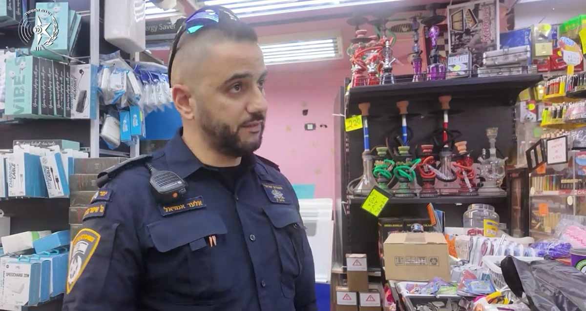 היערכות מוגברת לפורים ברמת גן. שוטר עורך בדיקה בחנות.