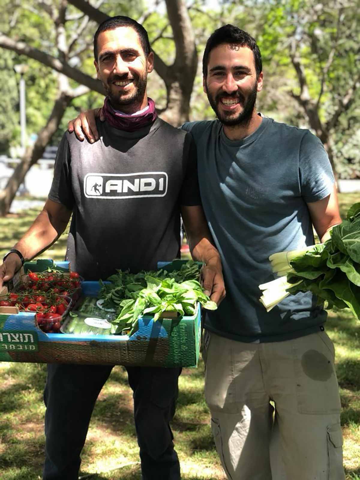 גבעתיים: שוק תמיכה בחקלאי הדרום, האחים דין וים ליכטמן אוחזים בקרטון עם ירקות.