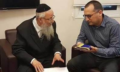 הרב הראשי של גבעתיים פנחס אדרי ז"ל, עם ראש העיר רן קוניק, האוחז בידו אביזר מקופל מבד.
