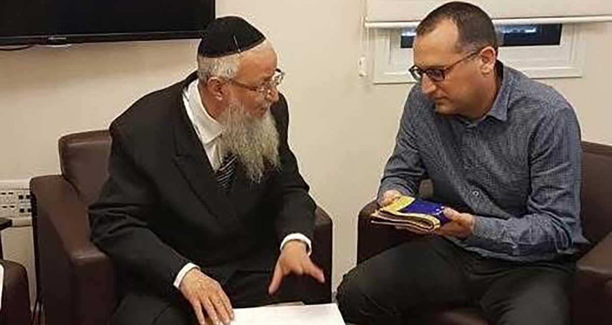הרב הראשי של גבעתיים פנחס אדרי ז"ל, עם ראש העיר רן קוניק, האוחז בידו אביזר מקופל מבד.