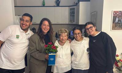 ארבעה בני נוער מר"ג מבקרים שורדי שואה בערב יום השואה ומעניקים שי ואיגרת.