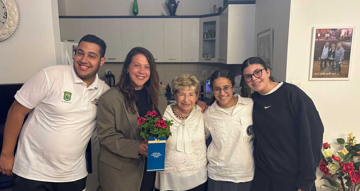 ארבעה בני נוער מר"ג מבקרים שורדי שואה בערב יום השואה ומעניקים שי ואיגרת.
