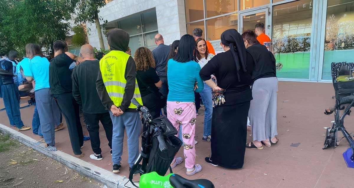 דיירי הבניין ברחוב בן אליעזר שפונו בגלל בולען הורשו לשוב לדירותיהם. הדיירים עומדים במדרכה ליד פתח הבניין.