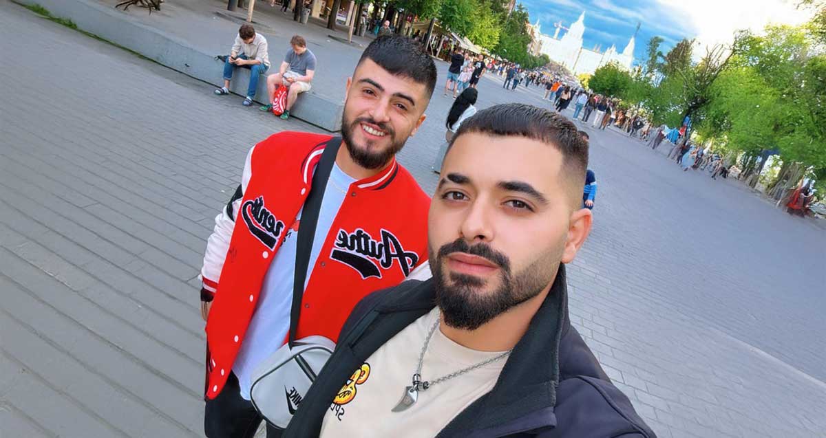 חסין חטום מדלית אל כרמל וחברו עבדללה עלוה מעוספיא, עומדים בטיילת גדולה, ואנשים רבים ברקע.