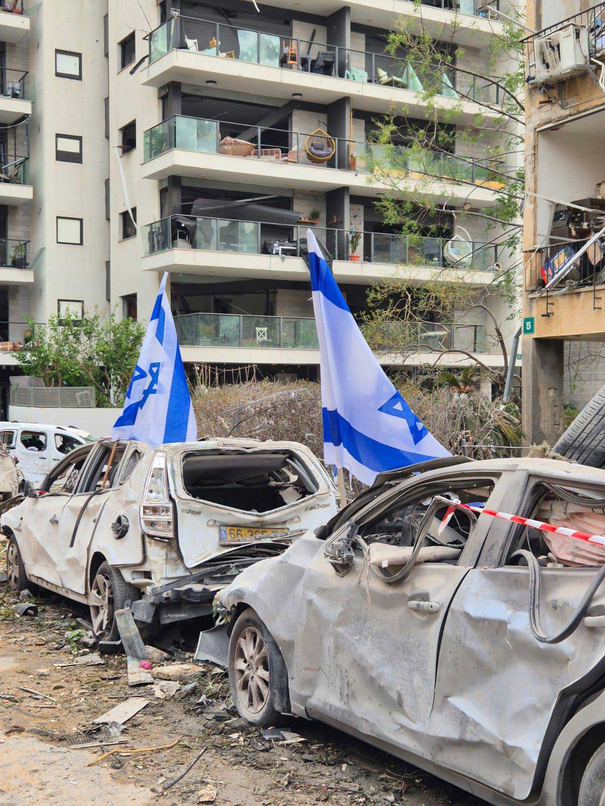 הפגיעה בבניין של טיל מאירן. ומכוניות שנהרסו ברחוב.