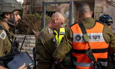 צוות של פיקוד העורף בזירת נפילת הטיל בקריית ביאליק שלושה קצינים אחד מהם עם הגב עם ווסט של פיקוד העורף והשני בדרגת תת אלוף ועוד קצין בדרגת סרן קסדה מחזיק אייפד ביד