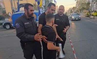 מחאות ברמת גן. שוטרים עוצרים מפגין האוחז רמקול ביד.