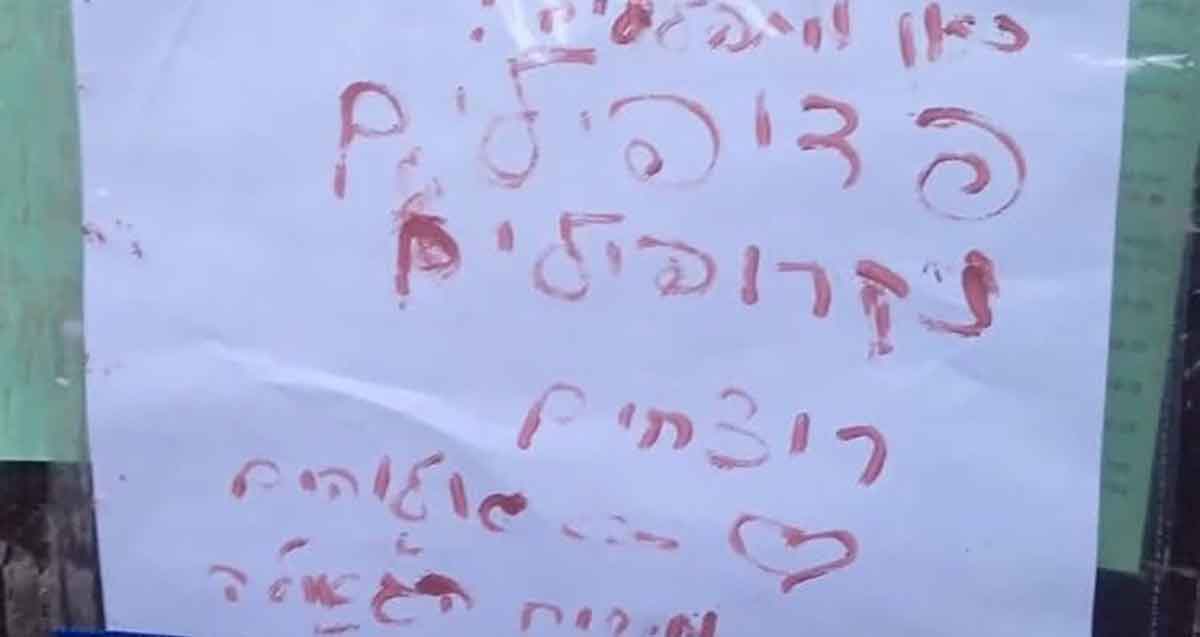 שלט שנאה בבית הכנסת "ההלכה" בר"ג. כיתוב בצבע אדום: כאן מתפללים פדופילים, נקרופילים, רוצחים, אלוהים משיח הגאולה, וסמל של לב