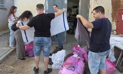 רווקות ורווקים מתנדבים בבית החולים לחיות בר בספארי. הצעירים מסדרים מגבות ומצעים. על הרצפה שקיות עם בדים.