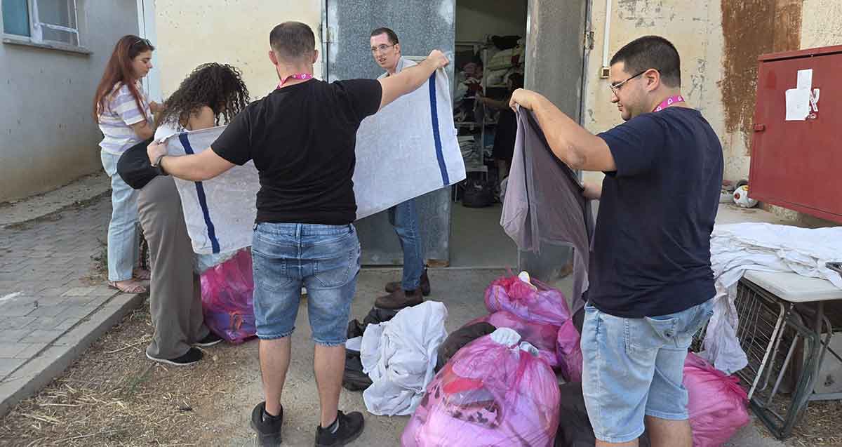 רווקות ורווקים מתנדבים בבית החולים לחיות בר בספארי. הצעירים מסדרים מגבות ומצעים. על הרצפה שקיות עם בדים.