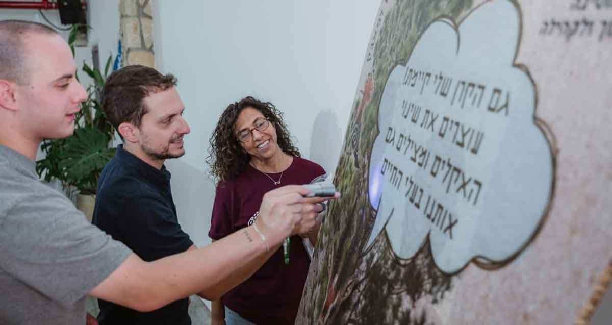 תוכנית אקו-לידרס במרכז הצעירים בגבעתיים. שלושה צעירים ליד פלקט עם כיתוב: גם הקרן שלי קיימת! עוצרים את שינוי האקלים ומצילים גם אותנו בעלי החיים.