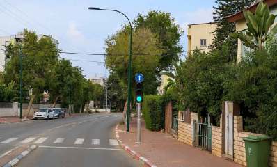 שכונת נגבה ברמת גן. איור AI. כביש של שני נתיבים ובתים של 2 עד 4 קומות עם עצים בחזית הבתים.