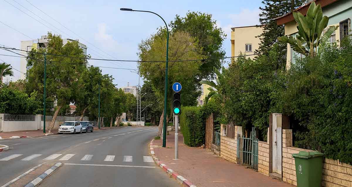 שכונת נגבה ברמת גן. איור AI. כביש של שני נתיבים ובתים של 2 עד 4 קומות עם עצים בחזית הבתים.