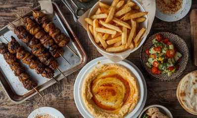 שולחן עם סלטים, חומוס, צ'יפס ושיפודי קבב. הדמיית בינה מלאכותית: רמת גן גבעתיים אונליין
