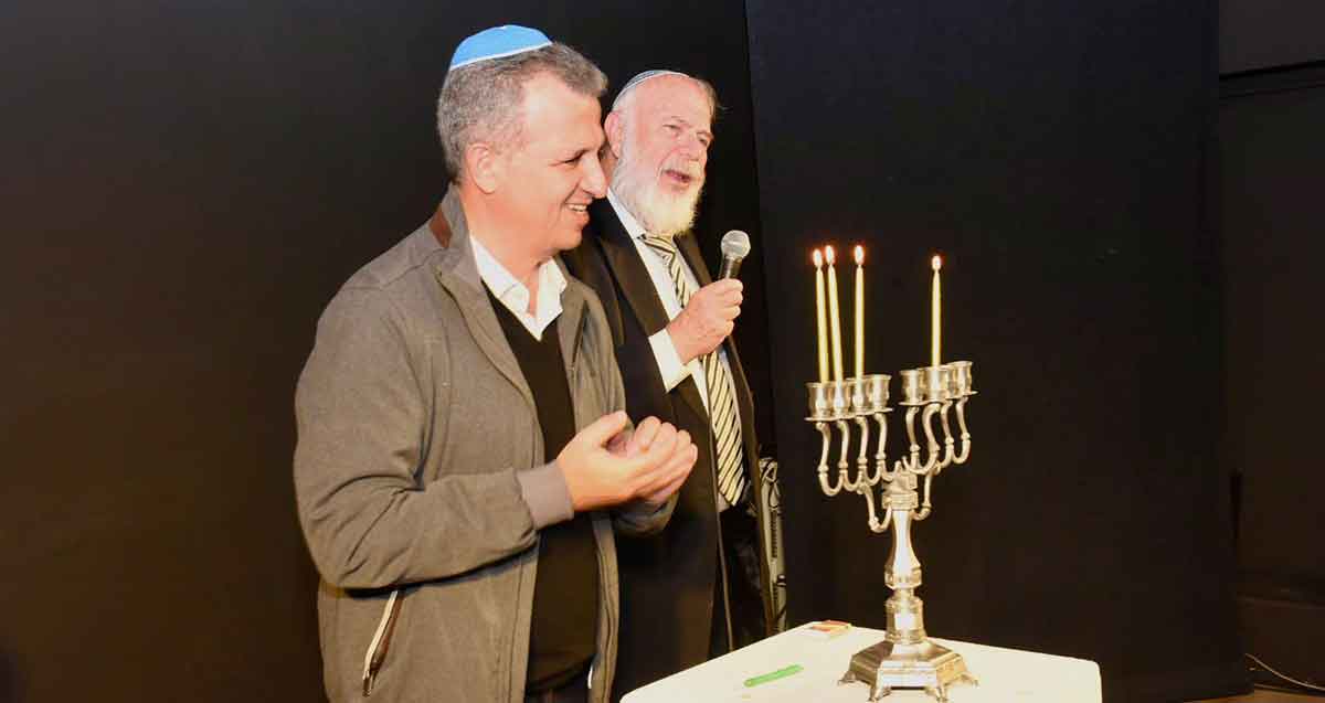 אירוע הדלקת נרות למשפחות שכולות ברמת גן. ראש העיר ואדם נוסף מדליקים נר שלישי.