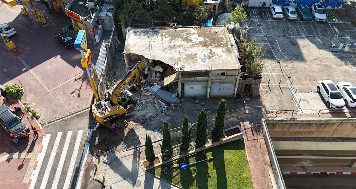 צילום מרחפן ש טרקטור הורס מבנה ישן בצומת עלית ברת גן. ליד גשר ומגרש חניה