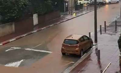 הצפה בשכונת נווה יהושע ברמת גן. הכביש מוצף. מכונית בצבע חום חונה ברחוב.