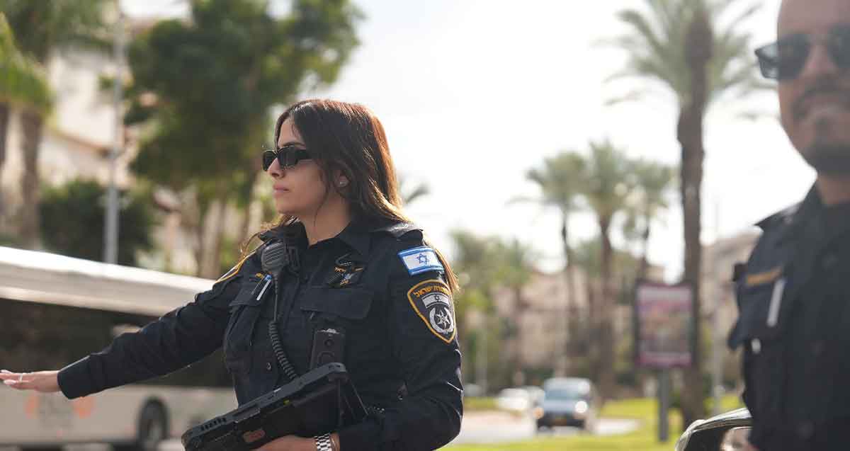 מבצע אכיפה בגבעתיים ורמת גן. שוטרת מסמנת ביד לעצור. לידה שוטר.