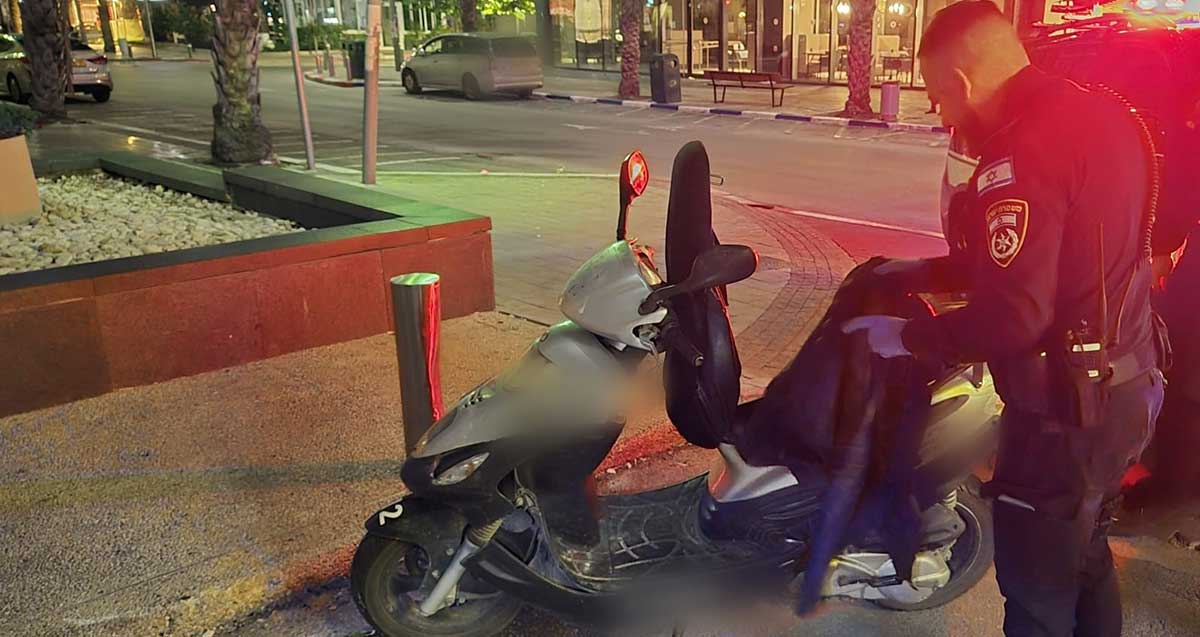 קטין גנב אופנוע ברמת גן. שוטר עומד ליד הקטנוע.
