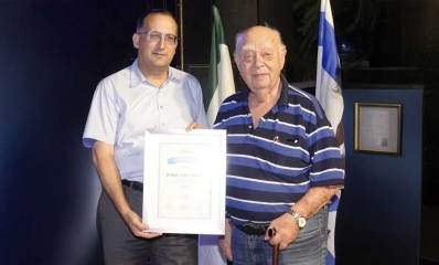 אפרים פרי הר ורן קוניק. רן קוניק אוחז בידו תעודה.