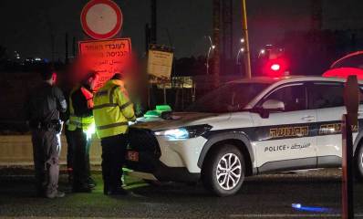 שוטרים וניידת משטרה מבצעים ביקורות ואכיפת תנועה בכביש