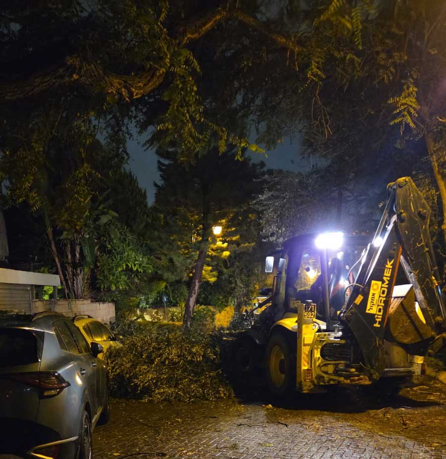 טרקטורון מפנה ענפי עצים שנתלשו בסופה