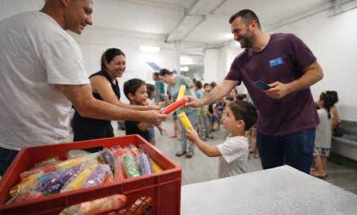 "מבצע ארטיק" במקלטים ברמת גן. איור AI. איש מחלק ארטיקים לילדים ולמבוגרים, מתוך ארגז פלסטיק מלא בארטיקים,