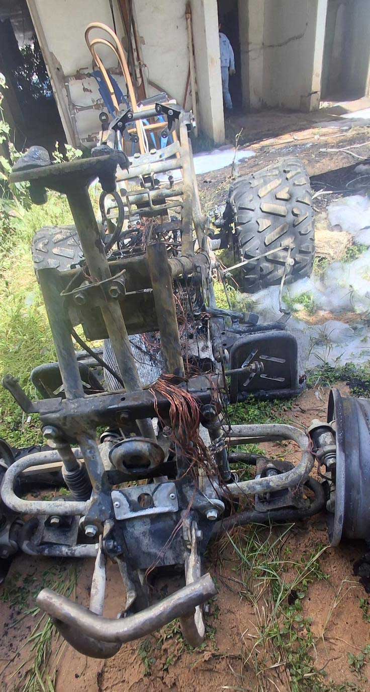 טרקטורון שרוף מונח על הדשא בחזית בניין