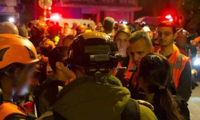 כרמל שאמה הכהן מוקף בכתבים ובכוחות הצלחה בזירת נפילת הטיל האירני. מתראיין