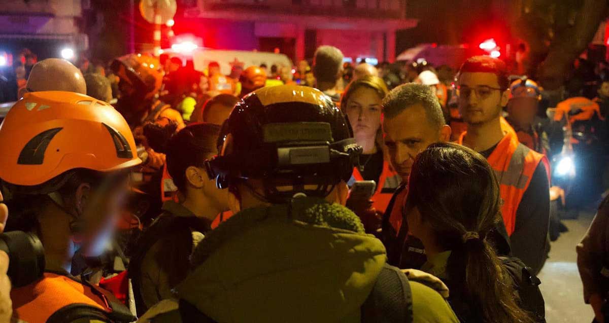 כרמל שאמה הכהן מוקף בכתבים ובכוחות הצלחה בזירת נפילת הטיל האירני. מתראיין