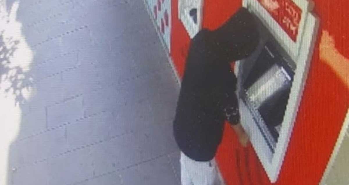 גנב כרטיסי אשראי ברמת גן. האיש עם קפוצ'ינו על הראש עומד לפני כספומט.