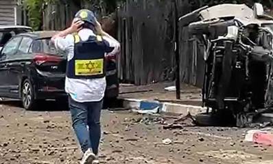 איש איחוד הצלה עם קסדה על ראשו ליד רכב מפוייח והפוך ושברים ברחוב בגבעתיים