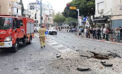 פגיעת טיל מצרר באזור רמת גן, באמצע כביש ונפער בור. רכב כבאות והצלה ליד מקום הנפילה.
