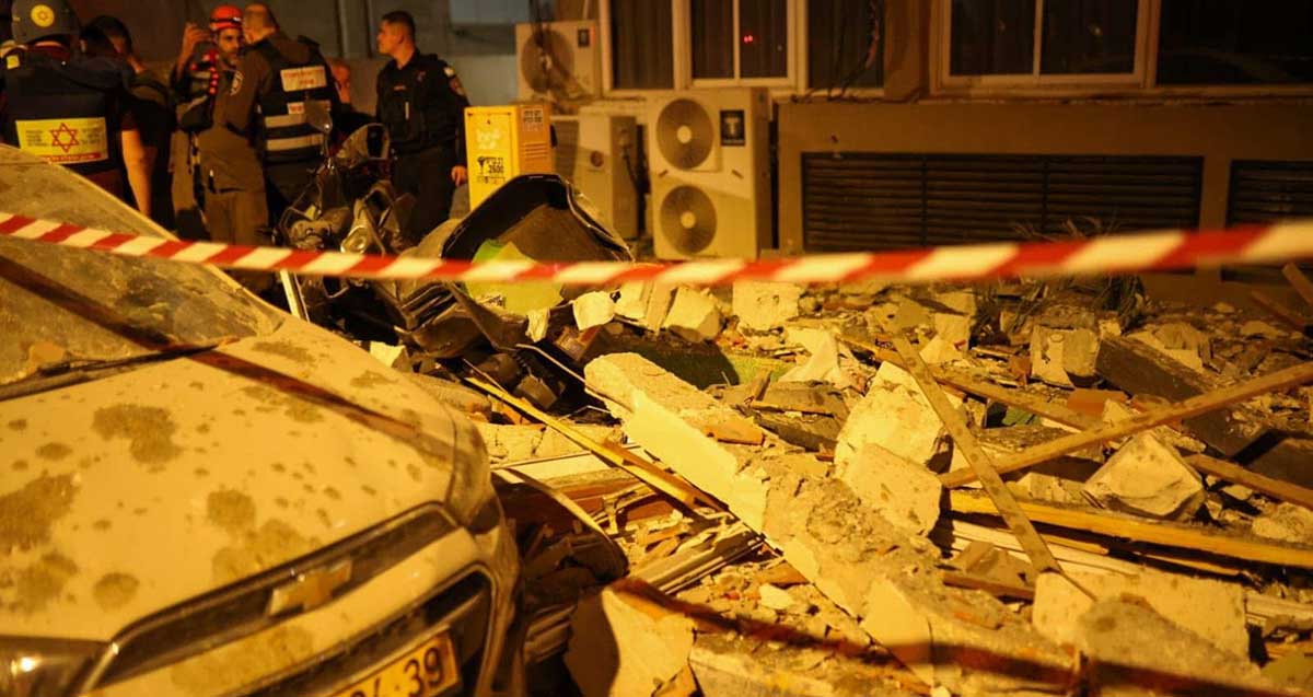 שברים של הריסות הבניין , רכב פגוע שוטרים ואנשי הצלה בזירת נפילת הטיל האירני