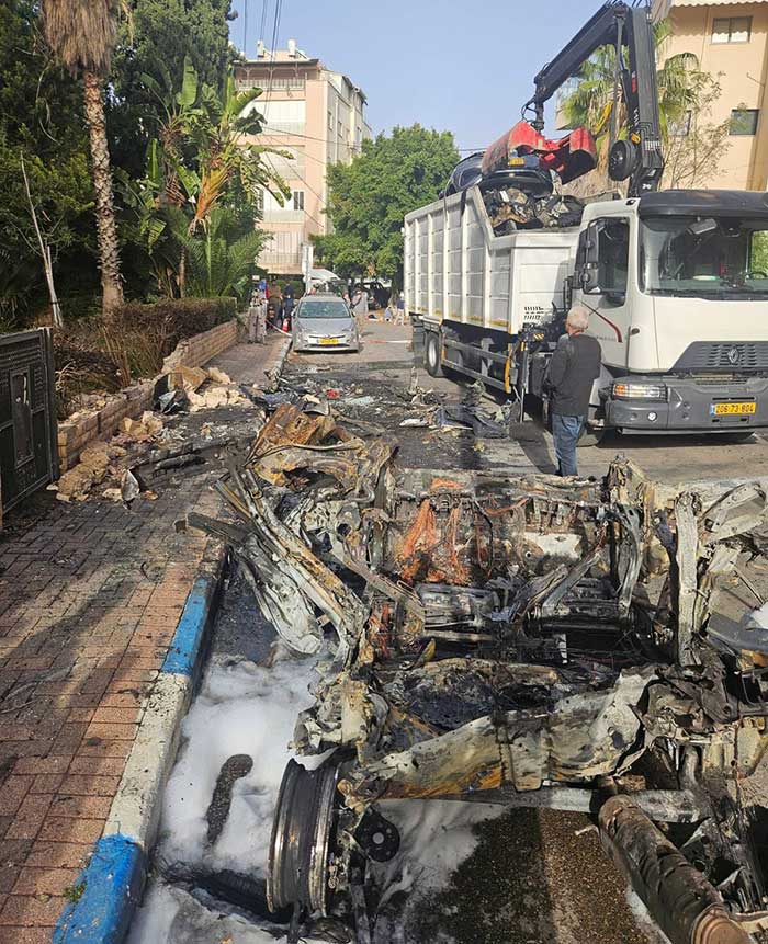 משאית עם מנוף מפנה שברי רכבים שנשרפו בגבעתיים