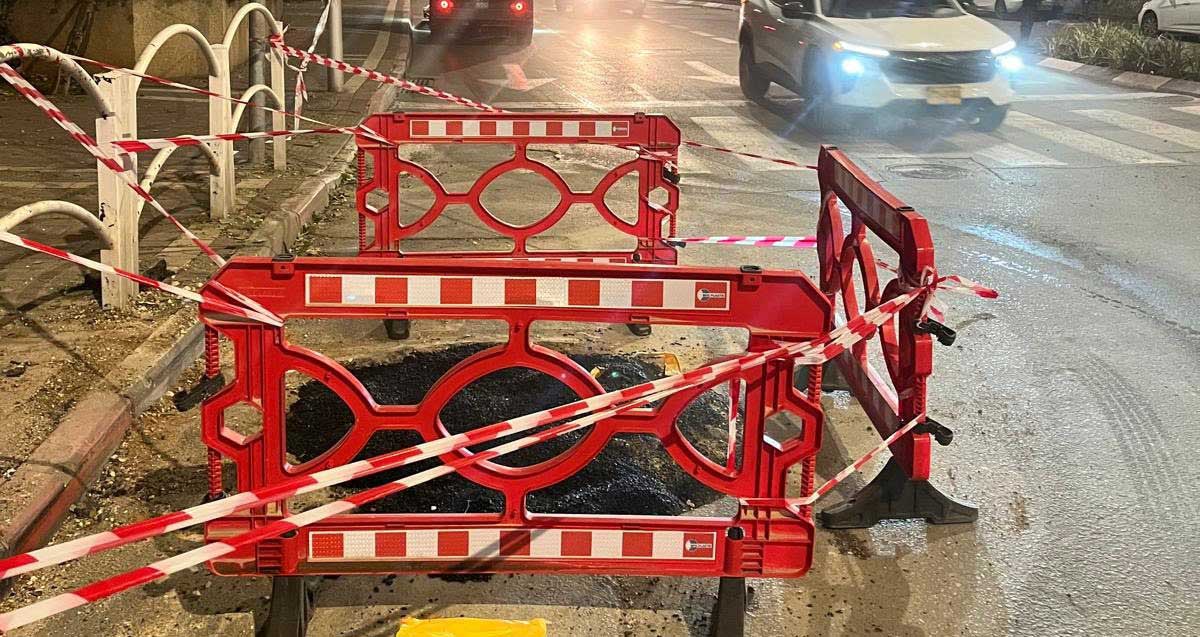 גדרות וסרטי סימון חוסמים בור שנפער בכביש בגבעתיים כתוצאה נפילות של טלים ושברי ירוט