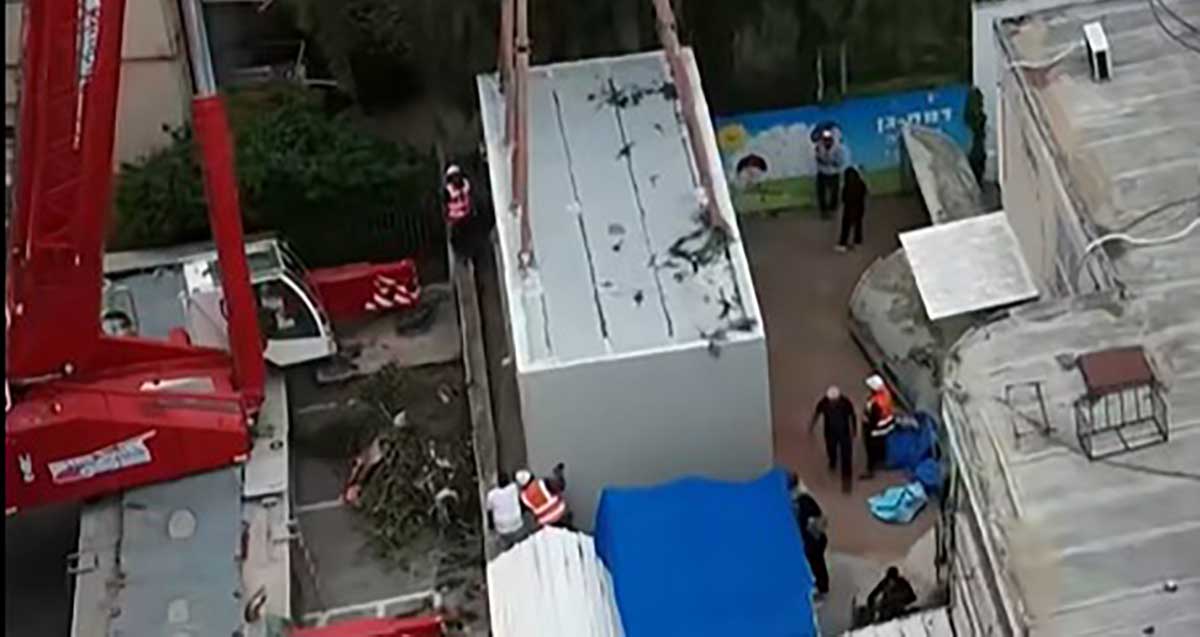 מיגון מעונות ברמת גן. מיגונית מוצבת בעזרת מנוף בחצר בניין.