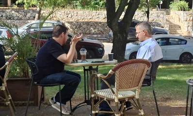כרמל שאמה עם אסף זמיר מסבים לשולחן במרפסת של בית קפה