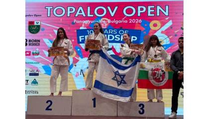 זוכת מדליית הזהב בתחרות ג'ודו בינלאומית - גל בן-וקיל מגבעתיים. על דוכן המנצחות, ביד אחת אוחזת בדגל ישראל וביד שנייה תמונה.